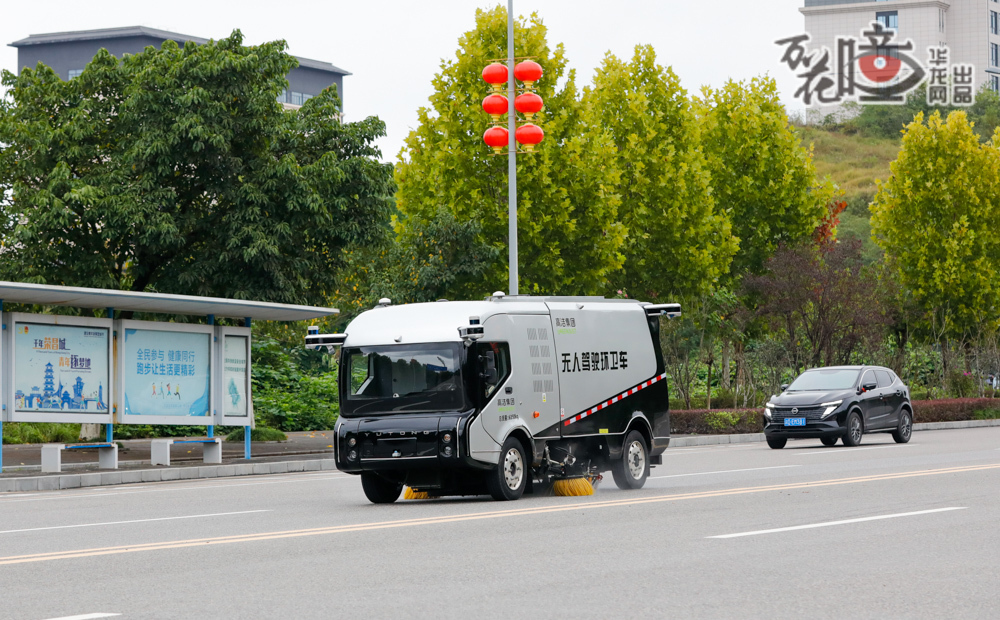  在榮昌的主干道上，一輛無人駕駛環衛車正悄然前行，車輛的掃刷無限貼近路沿石，不放過任何一處縫隙間的微塵，沖洗與清掃同步進行，它行經的每一寸道路，都被輕輕拭亮。來自高潔集團的環衛工人劉佐箱今年50歲，曾手握清掃車方向盤的他，如今換了一個身份，成為這輛無人駕駛環衛車的安全員與守護者，從駕駛者變成了科技的同行者。