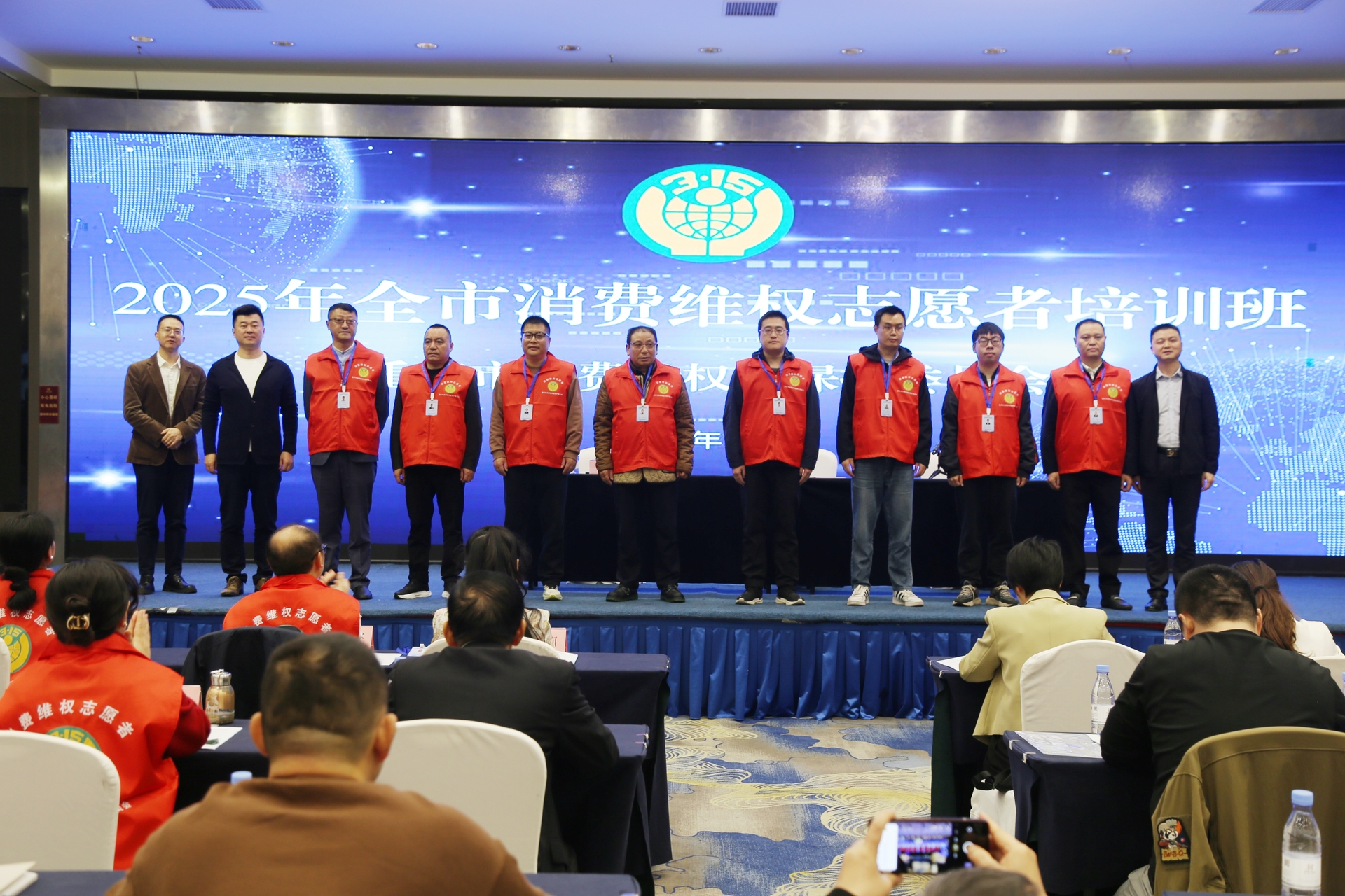培訓會現場為志愿者代表頒證書和統一標識服裝。重慶市消費者權益保護委員會供圖