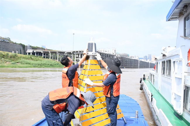 工作人員對專用航標進行維護保養。寸灘港城公司供圖