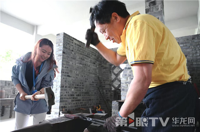 記者在“鄧家刀”非遺體驗館體驗打鐵。第1眼TV-華龍網(wǎng)記者 劉潤 攝