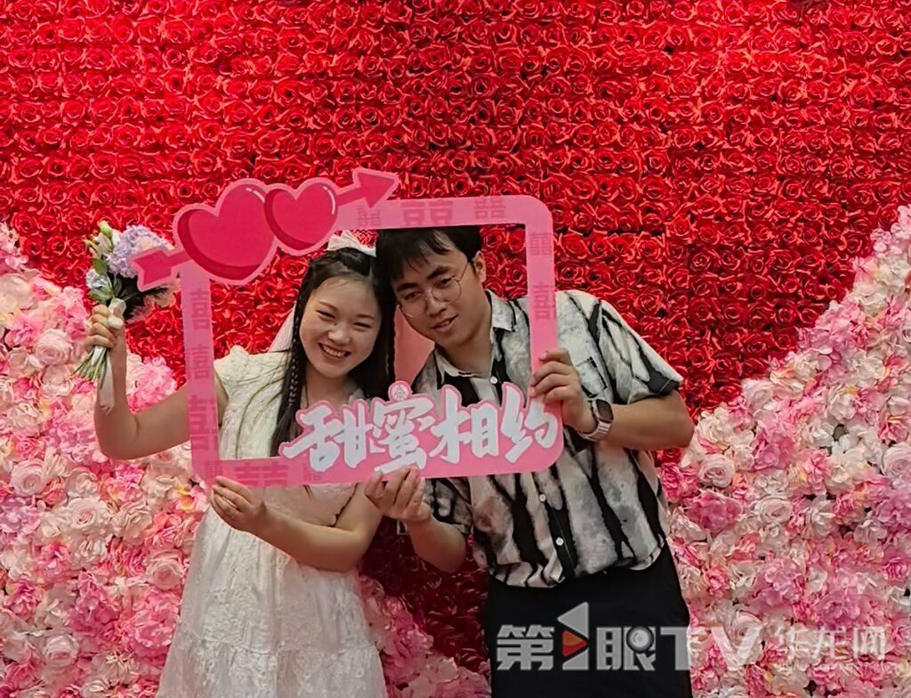 新人在花墻前合影。第1眼TV-華龍網 李舒 攝