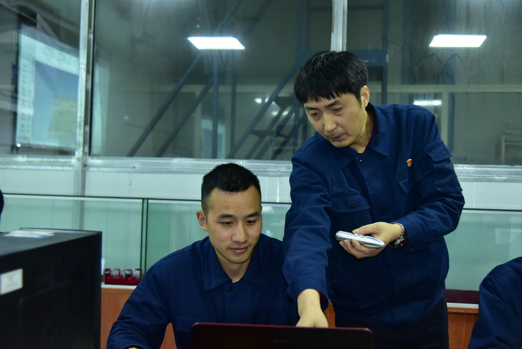 重慶鐵馬工業集團首席技師廖明指導學徒數控編程。重慶市人力社保局供圖