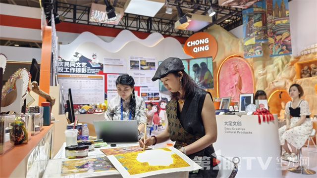 綦江農(nóng)民版畫(huà)院院長(zhǎng)劉月現(xiàn)場(chǎng)展示版畫(huà)繪制。張雅萍 攝