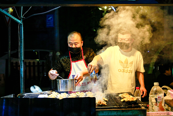 北泉夜市攤主忙碌著備餐。通訊員 熊輝 攝