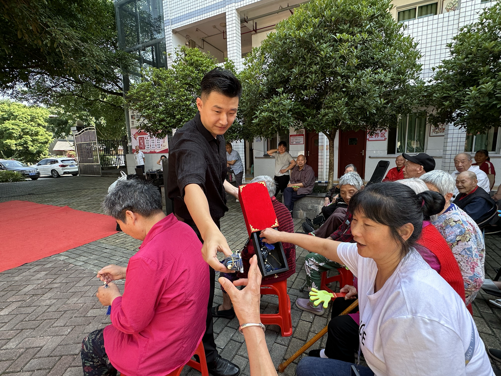 變魔術環節,工作人員為居民送上艾草香囊。主辦方供圖