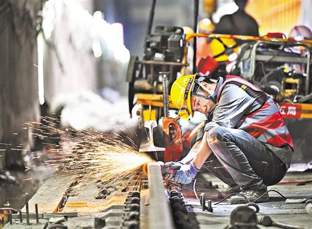 The picture shows constructors’ polishing operation for the weld of steel rail