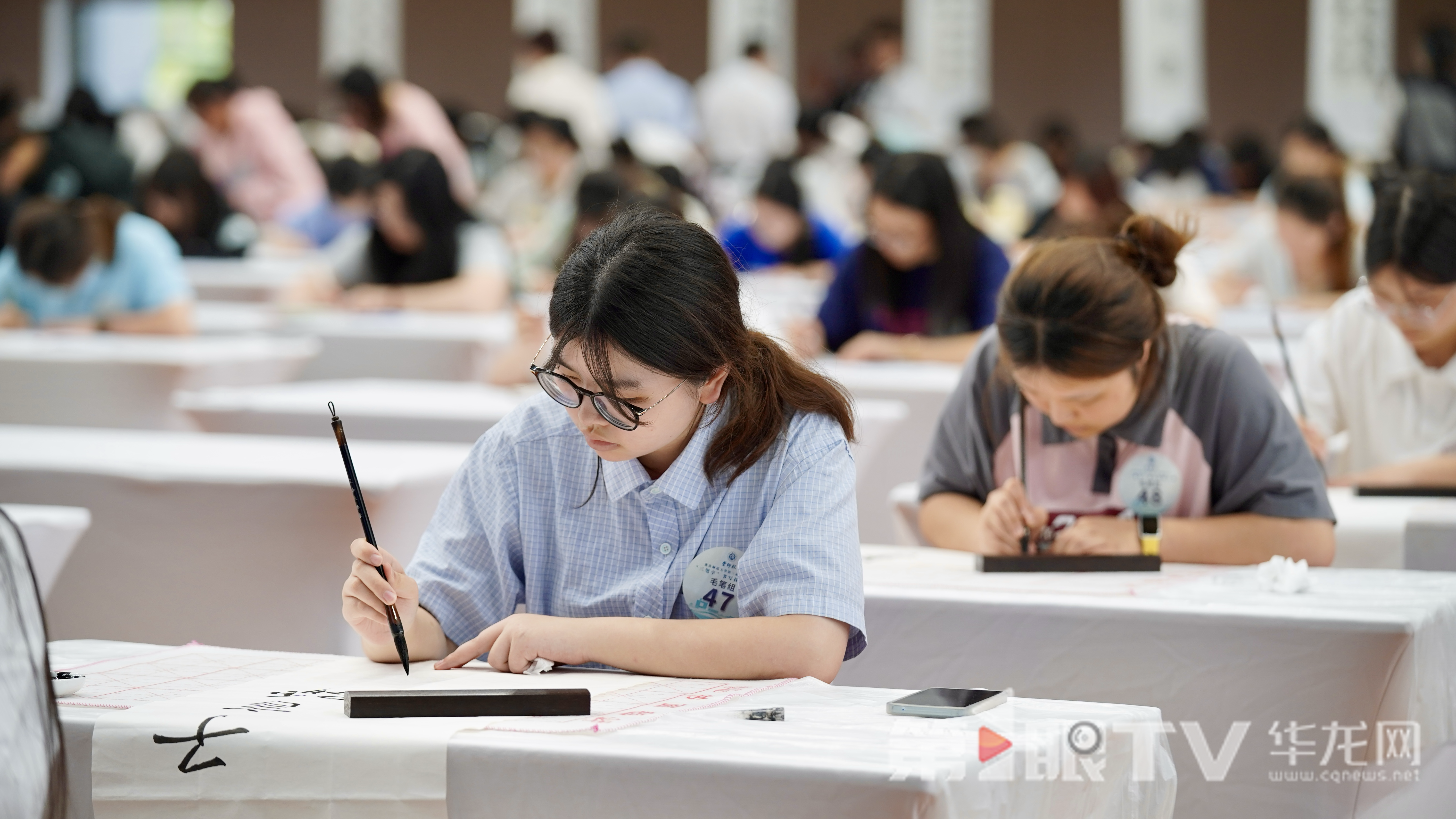 学生正在写毛笔字。 第1眼TV-华龙网记者 刘钊 摄