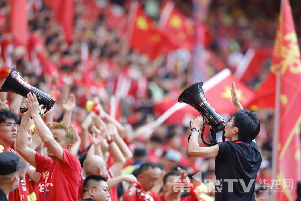 重庆龙兴足球场看台，球迷高举国旗、手持扩音器呐喊，点燃红色助威浪潮。第1眼TV-华龙网记者 石涛 摄
