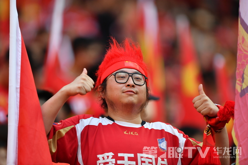 球迷红发造型竖大拇指，用个性姿态传递对国足的坚定信心。第1眼TV-华龙网记者 李一鸣 摄