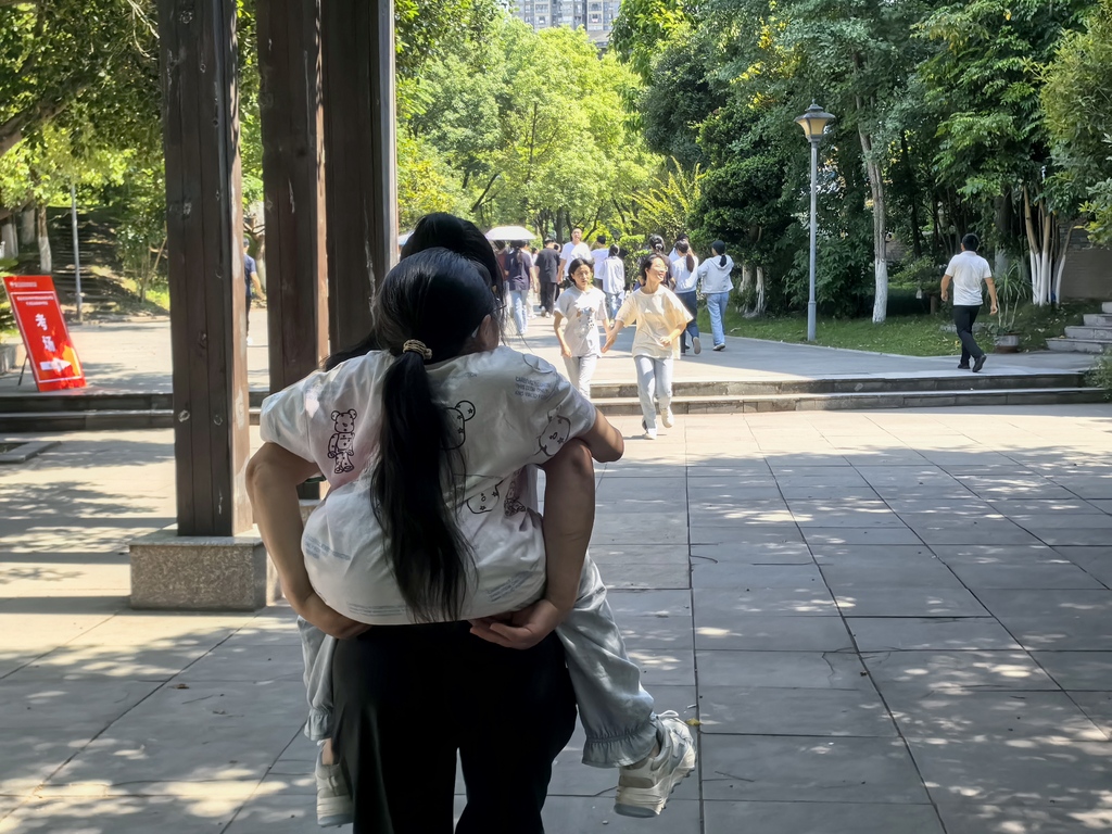 梁萬菊背著梁娜娜進考場。開州區融媒體中心供圖