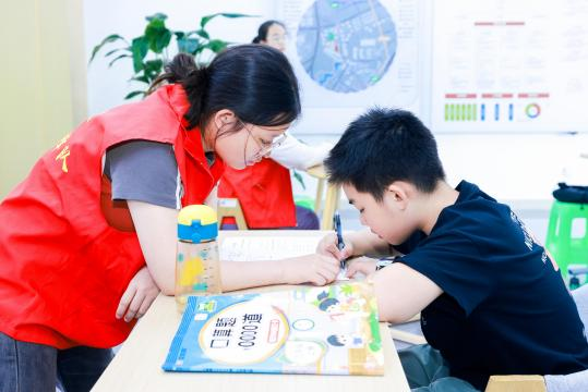 圖片5 在暑期托管中，志愿者進(jìn)行作業(yè)輔導(dǎo)。第1眼TV-華龍網(wǎng) 姬一鳴 攝