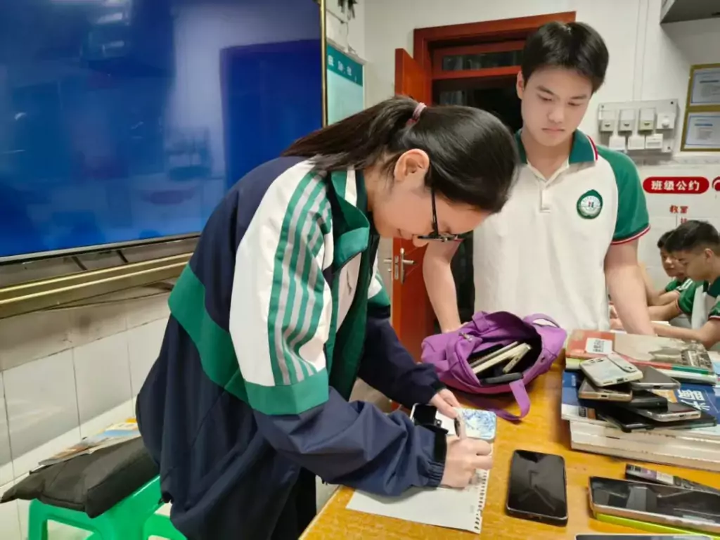 江北中学,学生上交手机后在进行登记。学校供图