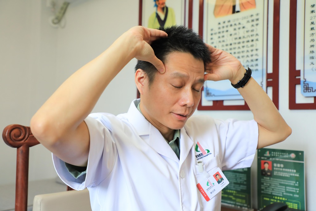 西南醫(yī)院江北院區(qū)中醫(yī)康復(fù)科主任江曉霽示范按揉太陽穴。 西南醫(yī)院江北院區(qū)供圖
