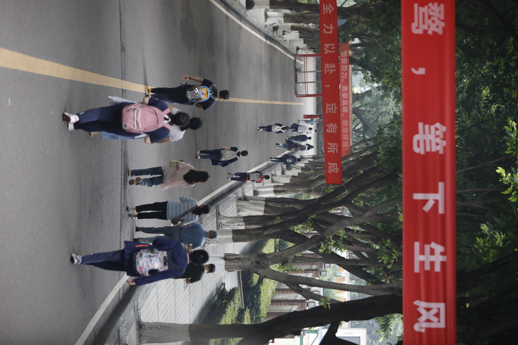 重慶一中考點，高考考生和監(jiān)考老師正陸續(xù)進入考點。 