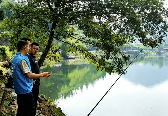 志愿者向垂釣群眾宣傳禁漁政策。秀山縣融媒體中心供圖
