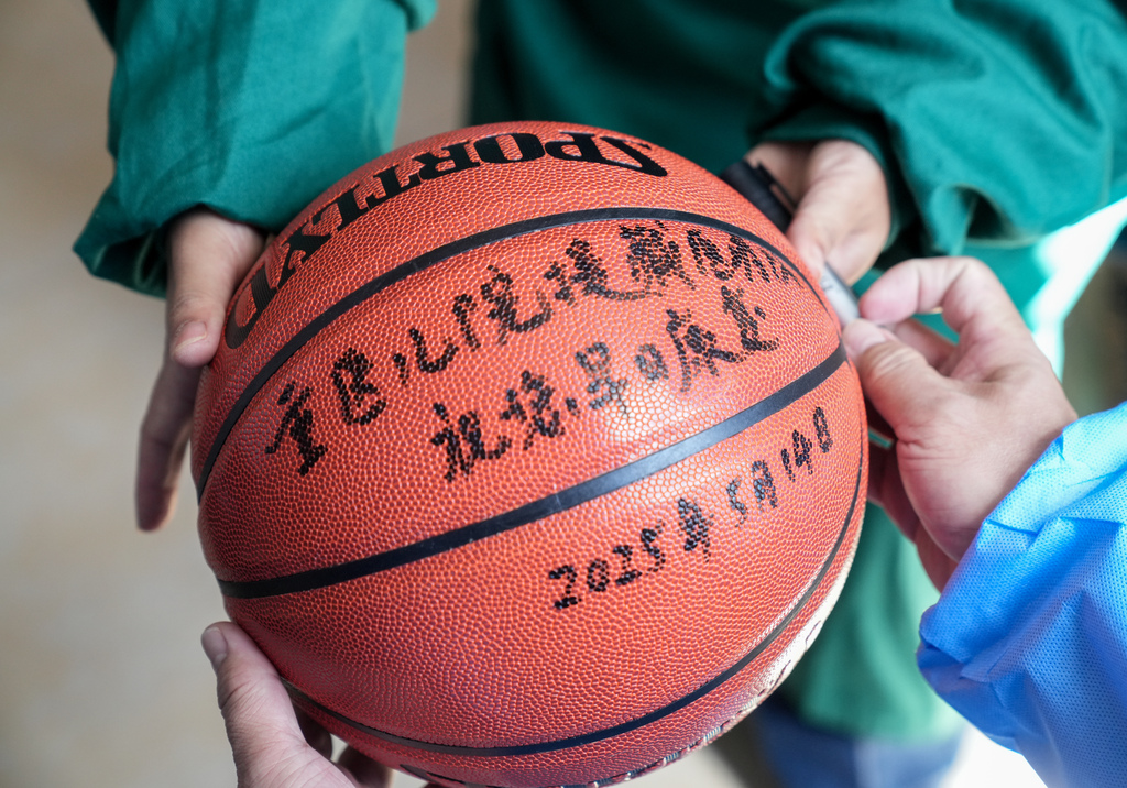 手术后,医生为洛桑罗布送上篮球。 重庆医科大学附属儿童医院供图