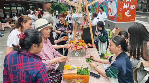 志愿者們為居民制作手工絹花。通訊員 李柄燕 攝