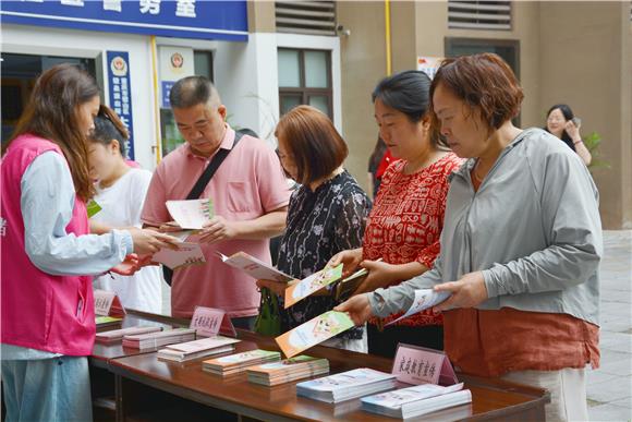 璧山區(qū)巾幗志愿者正在向家長發(fā)放家庭教育知識手冊。璧山區(qū)婦聯(lián)供圖