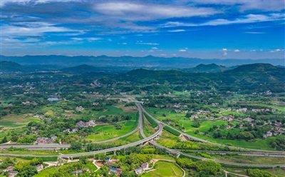 梁開高速?云龍鎮段石蓮樞紐互通，寬闊的道路與農田、民居緊密相連，融為一體。