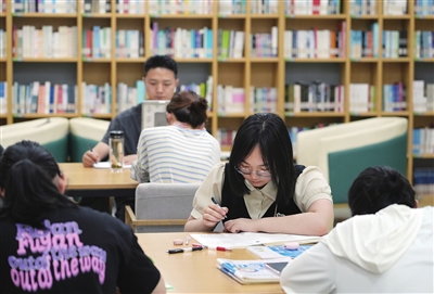梁平區(qū)少兒圖書館，學生在認真閱讀書籍，享受靜謐的夏日書香氛圍。