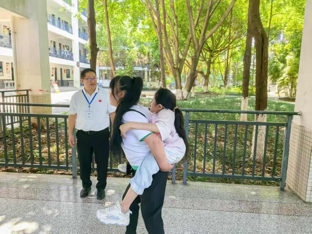 母親梁萬菊背著娜娜進考場。通訊員 向煉 王曉宇 張中鑫 攝
