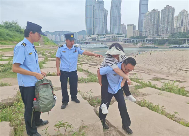 街道綜合服務隊在江灘公園幫助行動不便的游客。江北城街道供圖 第1眼TV-華龍網(wǎng)發(fā)