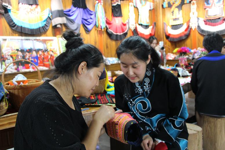 團隊成員向繡娘學(xué)刺繡。通訊員 戎欣恬 攝