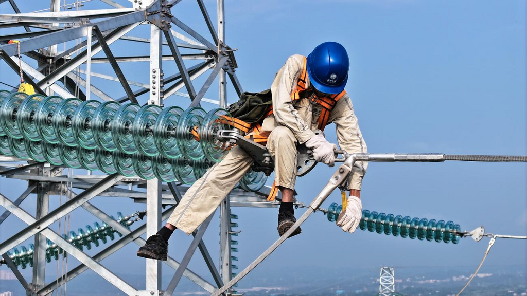 7月16日，重庆川东电力公司员工在李渡新区对220千伏枣涪北线57号塔线夹发热危急缺陷进行紧急处理，保障电力设备安全稳定运行。受访单位供图