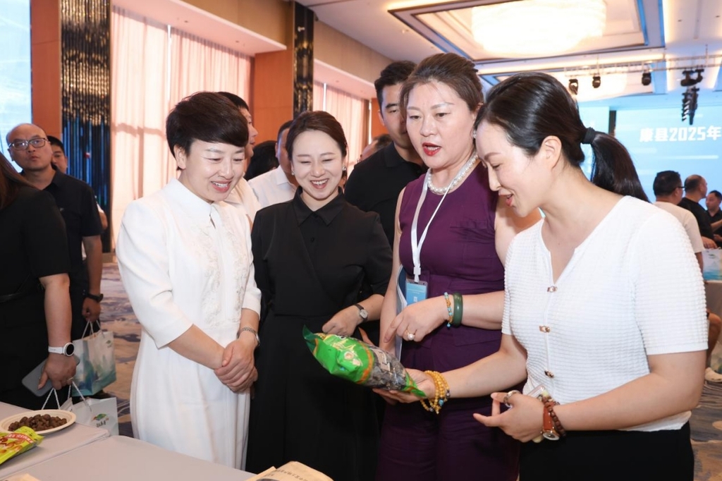 与会嘉宾与市民品鉴康县农特产品。主办方供图