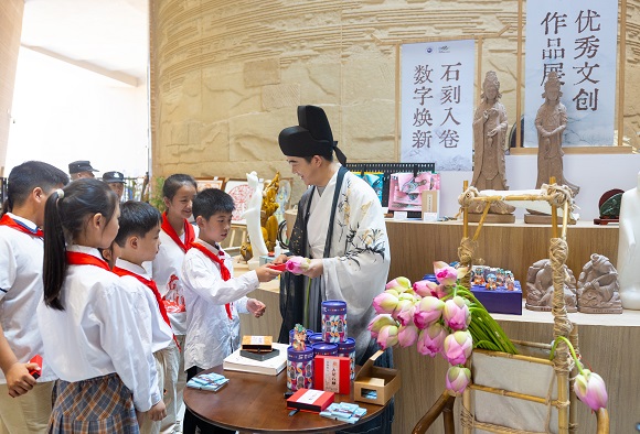 書(shū)博會(huì)大足分會(huì)場(chǎng)現(xiàn)場(chǎng)，“書(shū)生”正為孩子們講解課本知識(shí)。 大足區(qū)委宣傳部供圖 第1眼TV-華龍網(wǎng)發(fā)