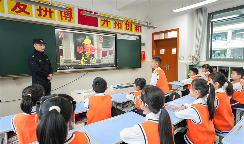 桂陽(yáng)街道民警為西湖小學(xué)的學(xué)生講解交通安全。墊江縣融媒體中心供圖 第1眼TV-華龍網(wǎng)發(fā)