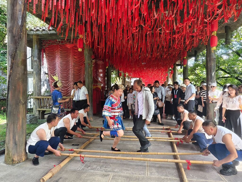 来宾与苗族阿哥阿妹跳起土家族竹竿舞。重庆市外办供图