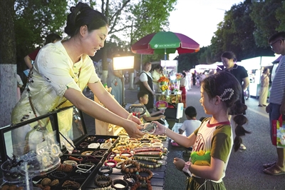 雙桂湖國家濕地公園的夜市,商家在介紹攤位上的飾品。記者 向成國 攝