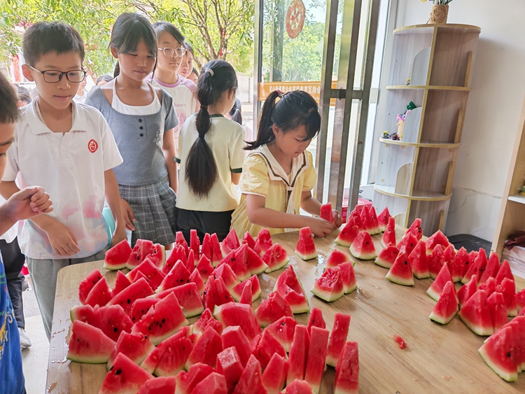 孩子们品尝自己种的西瓜。通讯员 孙艺荣 摄