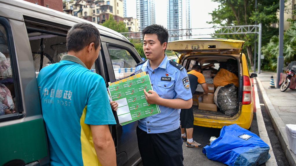 民警向快遞員介紹反詐貼紙。 警方供圖