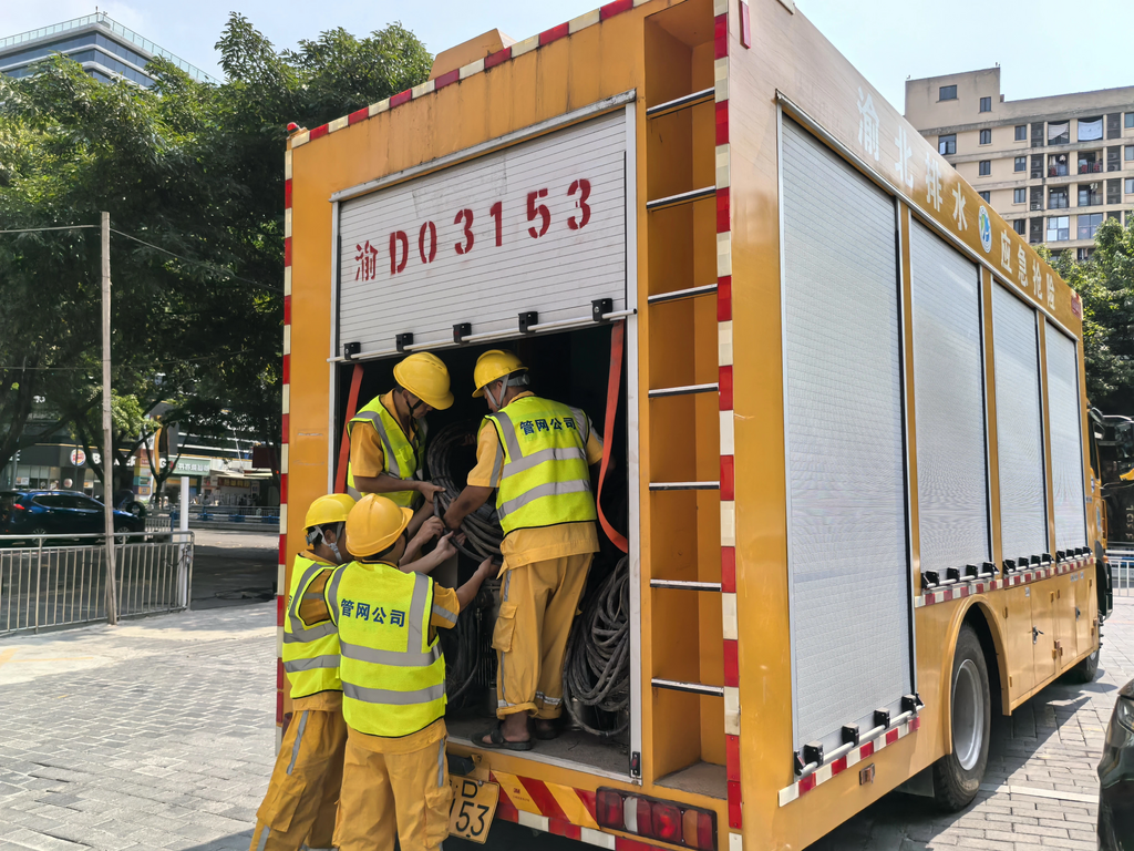 工作人员在下雨前做准备。 市住房城乡建委供图
