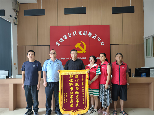 居民廖先生為寶城寺社區(qū)民警、網(wǎng)格員送錦旗致謝。通訊員 王軒 攝
