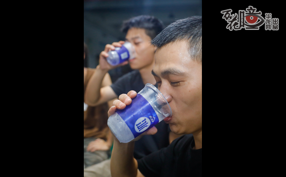 該配件廠的工作人員正暢快地喝著冰水，汗?jié)竦囊路N在背上，臉上卻綻開了滿足的笑容，疲憊在甘洌的冰水和短暫的談笑風(fēng)生中悄然消融。