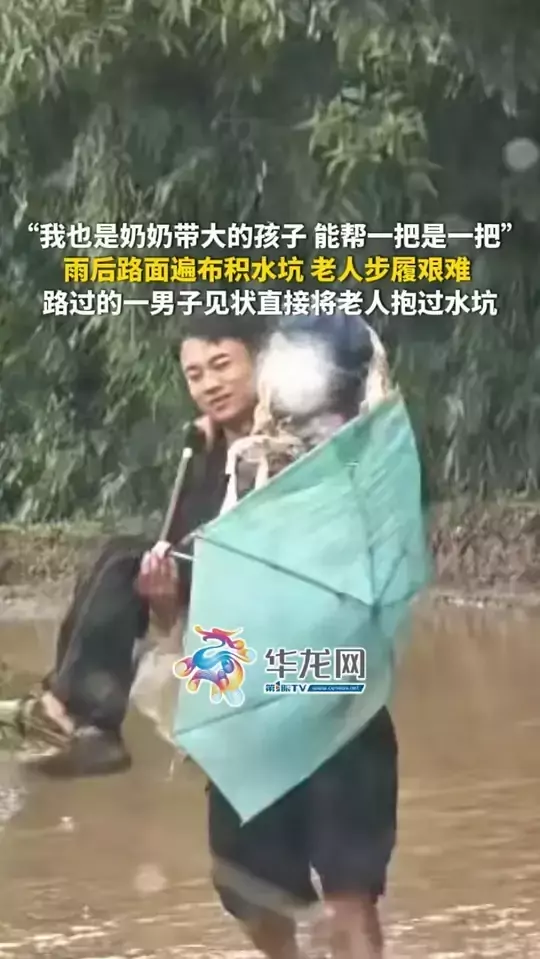 “我也是奶奶带大的孩子 能帮一把是一把！”雨后路面遍布积水坑，老人步履艰难，路过一男子见状直接将老人抱过水坑！