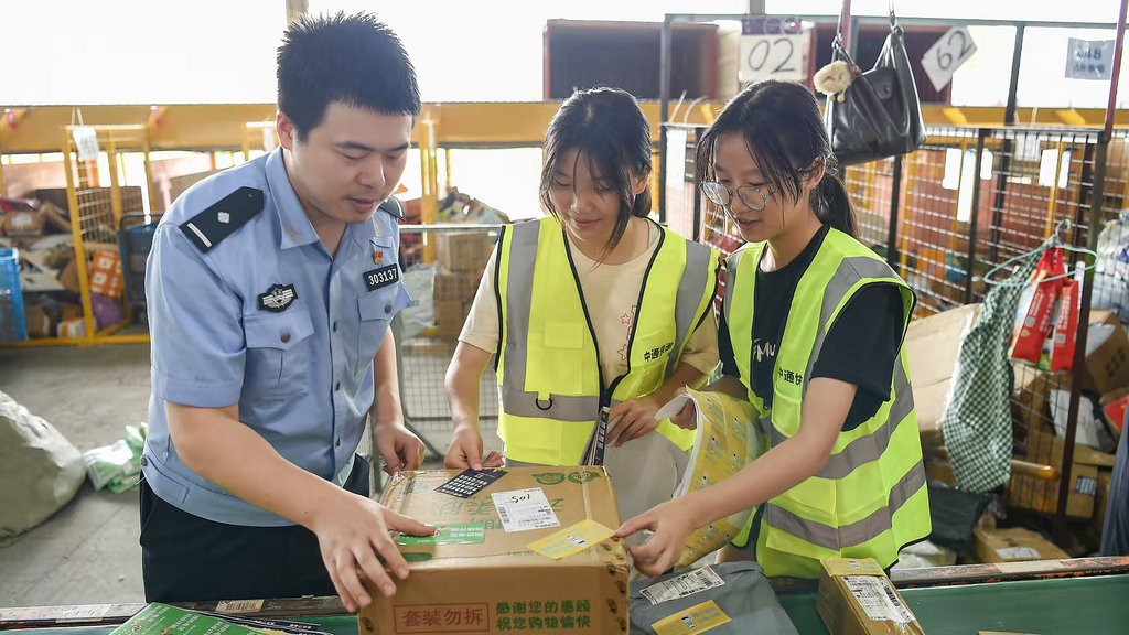 民警與快遞工作人員一起給快遞貼上反詐貼紙。 警方供圖